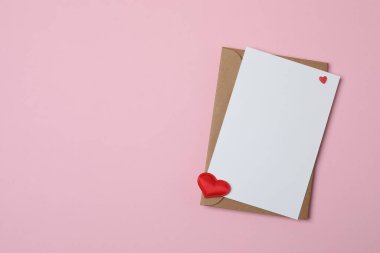 Sevgililer Günün kutlu olsun. Tebrik kartı ve pembe arka planda dekoratif kalp ile zarf, üst görünüm