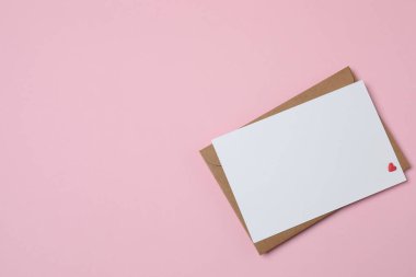 Sevgililer Günün kutlu olsun. Tebrik kartı ve pembe arka planda dekoratif kalp ile zarf, üst görünüm