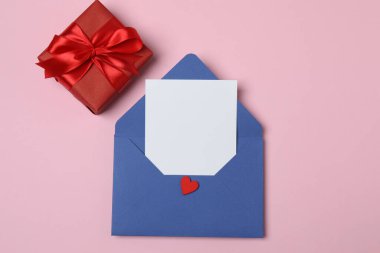 Sevgililer Günün kutlu olsun. Tebrik kartı ve pembe arka planda dekoratif kalp ile zarf, üst görünüm