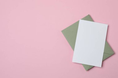 Sevgililer Günün kutlu olsun. Tebrik kartı ve pembe arka planda dekoratif kalp ile zarf, üst görünüm