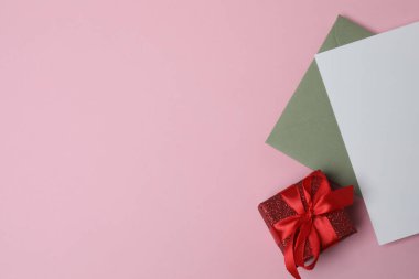 Sevgililer Günün kutlu olsun. Tebrik kartı ve pembe arka planda dekoratif kalp ile zarf, üst görünüm