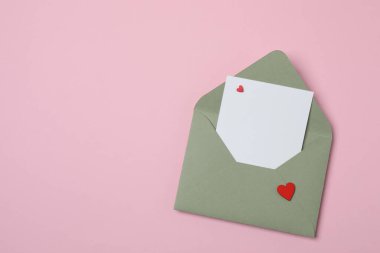 Sevgililer Günün kutlu olsun. Tebrik kartı ve pembe arka planda dekoratif kalp ile zarf, üst görünüm