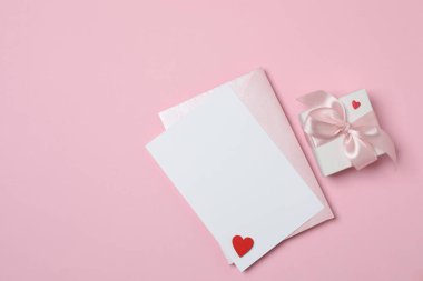 Sevgililer Günün kutlu olsun. Tebrik kartı ve pembe arka planda dekoratif kalp ile zarf, üst görünüm