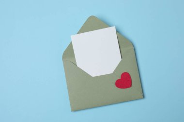 Sevgililer Günün kutlu olsun. Tebrik kartı ve mavi arka planda dekoratif kalp ile zarf, üst görünüm