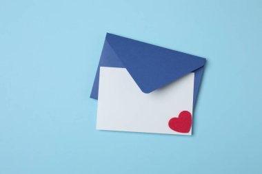 Sevgililer Günün kutlu olsun. Tebrik kartı ve mavi arka planda dekoratif kalp ile zarf, üst görünüm