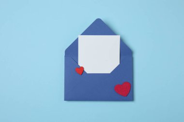 Sevgililer Günün kutlu olsun. Tebrik kartı ve mavi arka planda dekoratif kalp ile zarf, üst görünüm