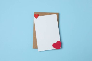 Sevgililer Günün kutlu olsun. Tebrik kartı ve mavi arka planda dekoratif kalp ile zarf, üst görünüm