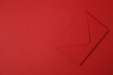 Sevgililer Günün kutlu olsun. Tebrik kartı ve kırmızı arka planda dekoratif kalp ile zarf, üst görünüm