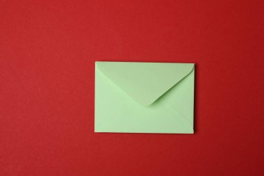 Sevgililer Günün kutlu olsun. Tebrik kartı ve kırmızı arka planda dekoratif kalp ile zarf, üst görünüm