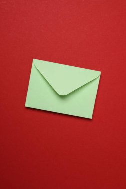 Sevgililer Günün kutlu olsun. Tebrik kartı ve kırmızı arka planda dekoratif kalp ile zarf, üst görünüm