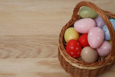 Paskalya tatili konsepti. Sepette yumurta ve ahşap bir masada tavşan.