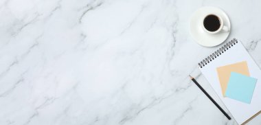 Kalem ve kahveyle masaya yaylı not defteri. Ofis kavramı. Üst görünüm.