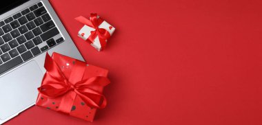 Hediye kutusu ve laptop ofis masasında. Tebrik için boş tebrik kartı ile üst görünüm düz yatıyordu.