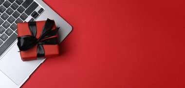 Hediye kutusu ve laptop ofis masasında. Tebrik için boş tebrik kartı ile üst görünüm düz yatıyordu.