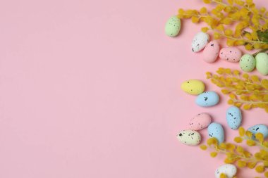 Parlak Paskalya kompozisyonu pastel yumurta figürleri ve pembe arka planda parlak çiçekler, heyecan verici şenlik havası ve bahar selamlaması.