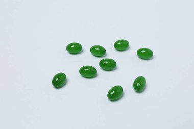 Beyaz arka planda haplar olan ilaç şişesi..