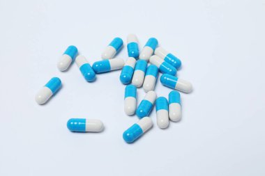 Beyaz arka planda haplar olan ilaç şişesi..