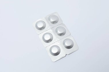 Beyaz arka planda haplar olan ilaç şişesi..