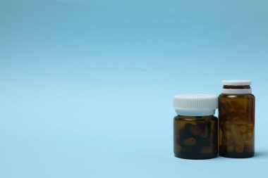 Mavi arka planda haplar olan ilaç şişesi..