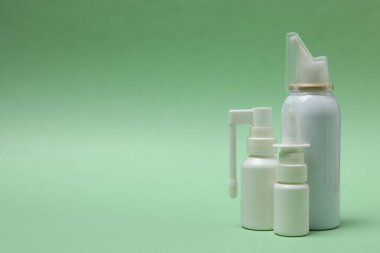 Yeşil arka planı olan beyaz krema şişesi.