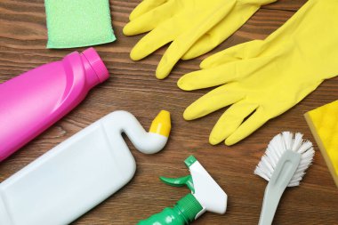 Ahşap bir masada ev temizleme malzemeleri.
