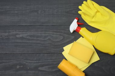 Ahşap bir masada ev temizleme malzemeleri.