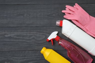 Ahşap bir masada ev temizleme malzemeleri.