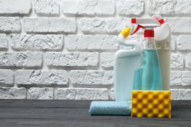 Ahşap bir masada ev temizleme malzemeleri.