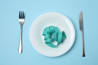 Beyaz bir tabakta şerit ölçüyorum. Diyet, Sağlık, Kilo