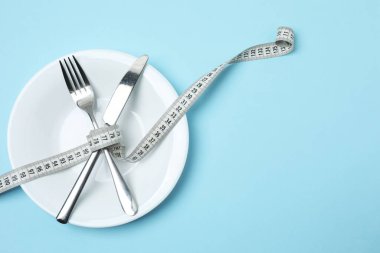 Beyaz bir tabakta şerit ölçüyorum. Diyet, Sağlık, Kilo