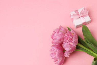 Lale buketi ve pembe arka planda hediye kutusu, metin için boşluk