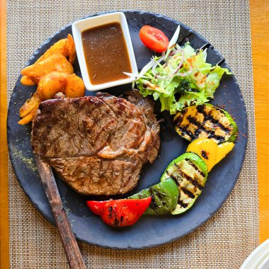 Restoranda gri bir tabakta biftek..