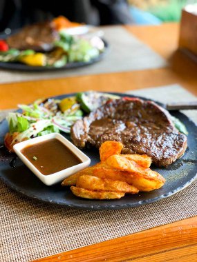 Restoranda gri bir tabakta biftek..