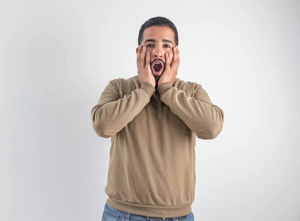 Dehşete düşmüş ya da hayretler içinde kalmış genç bir adamın yüzü ve ağzı açıktı.