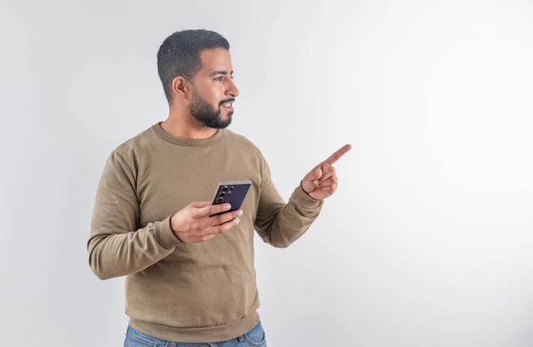 Sağ tarafta fotokopi çekerken cep telefonu kullanan süveter giyen genç adam.