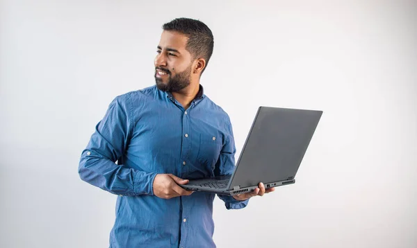 Düşünceli iş adamı elinde dizüstü bilgisayarla fikir üretmek için fotokopi alanına doğru bakıyor.