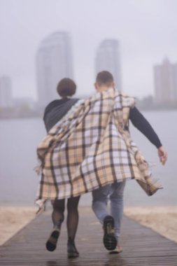 Birbirine aşık bir çift sisli bir günde rıhtımda koşuyor..