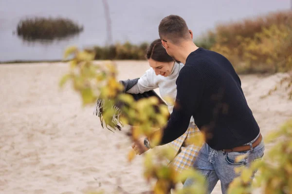 Un couple amoureux se promène le long du front de mer et de la forêt d'automne à travers les arbres jaunes — Photo