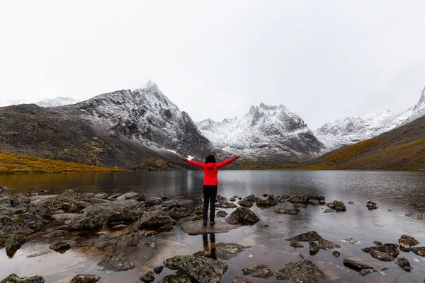 Menina de pé no lago com montanhas nevadas — Fotografia de Stock