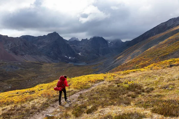 Mochila de mulher na trilha panorâmica de caminhadas cercada por montanhas acidentadas — Fotografia de Stock