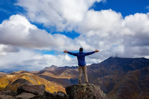 Homem com braços para cima olhando para Mountain Range em um dia de queda nublado — Fotografia de Stock