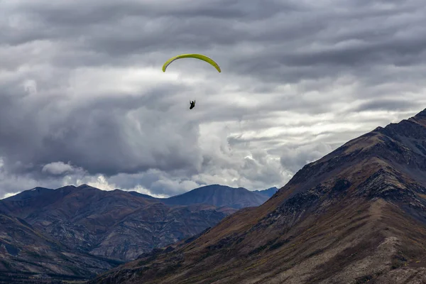 Parapendio che sorvola la catena montuosa panoramica nella natura canadese — Foto Stock