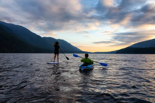 Přátelé na Scenic Lake Kayaking a Paddleboarding dohromady — Stock fotografie