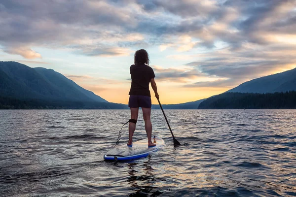 Paddleboarding donna sul lago panoramico al tramonto — Foto Stock