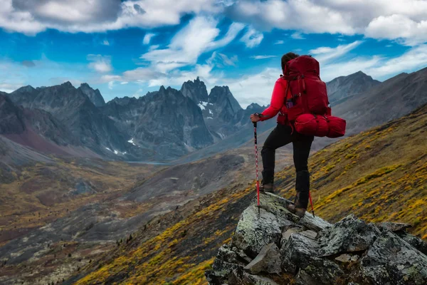 O femeie stând pe stânci uitându-se la vârfurile și valea montană pitorească — Fotografie, imagine de stoc