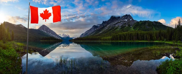 Kanadská národní vlajka před jezerem Marvel obklopená Skalistými horami — Stock fotografie
