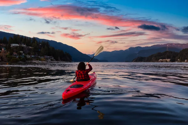 Chica aventurera remando en un kayak rojo brillante — Foto de Stock