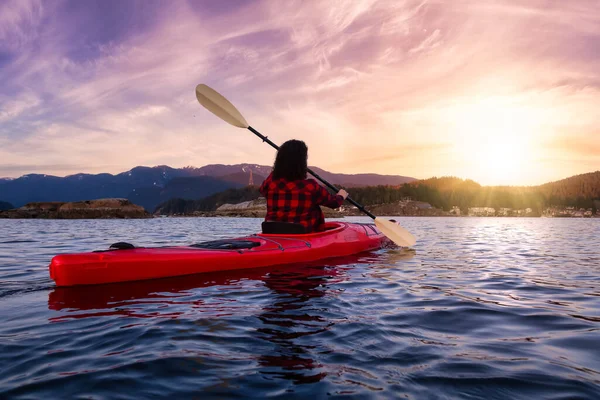 Chica aventurera remando en un kayak rojo brillante — Foto de Stock