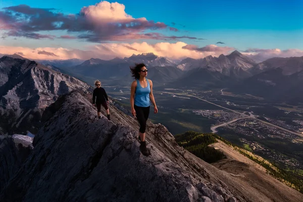 Chica aventurera está subiendo una montaña rocosa. — Foto de Stock