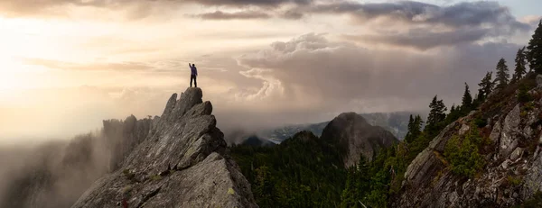 Dobrodružný muž na vrcholu rozeklané skalnaté hory. — Stock fotografie